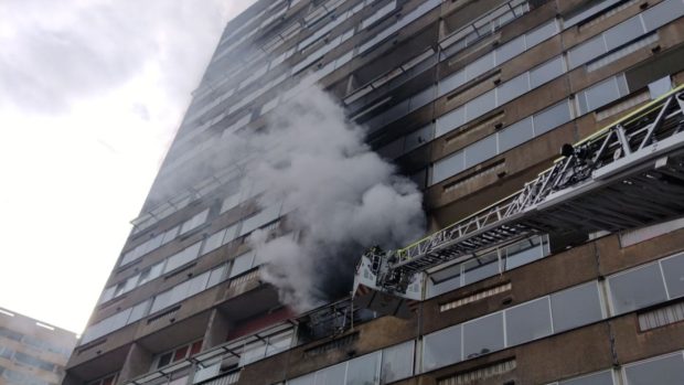 Hasiči zasahují u požáru bytu v panelovém domě na sídlišti v Březenecké ulici v Chomutově. Evakuovali 60 lidí