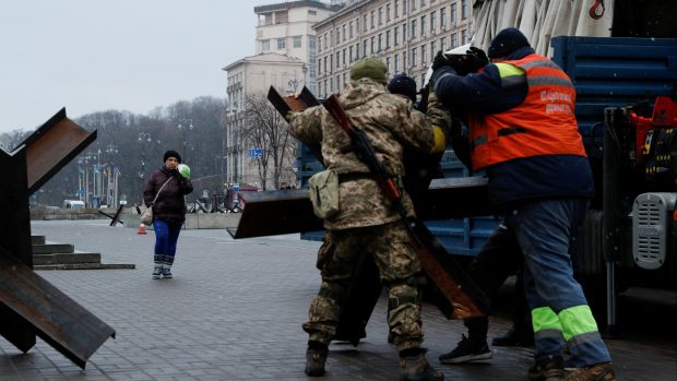 Vojáci a dobrovolníci umisťují protitankové zátarasy na check-pointu v centru Kyjeva