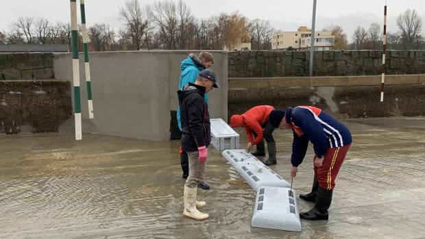 Trenéři vodního slalomu staví překážky na kanálu v pražské Troji