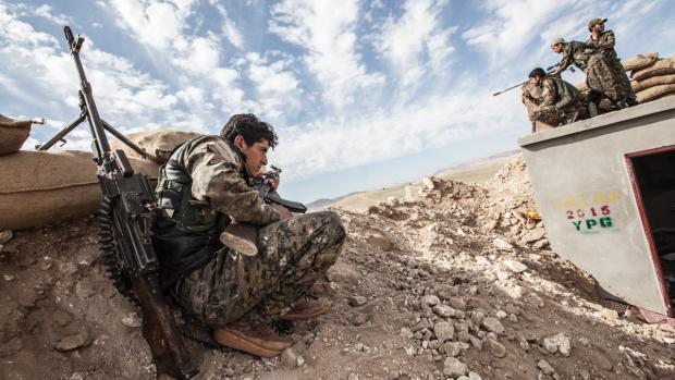 Kurdsko-arabské milice nedaleko přehrady Tišrín v severní Sýrii, na které pálí islamisté. Kurdské milice nesly hlavní tíhu bojů proti takzvanému Islámskému státu a tisíce jejich příslušníků také v boji padly.
