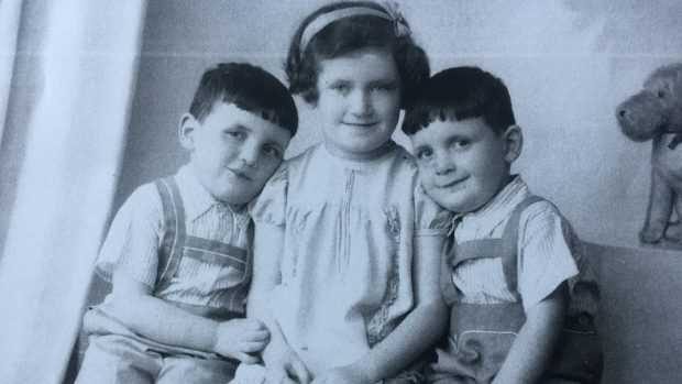 Dvojčata Jiří a Josef Fišerovi se svou starší sestrou Věrou. Snímek pochází z roku 1938. Věra později zahynula v plynové komoře, stejně jako matka dětí. Věře bylo tehdy 10 let.