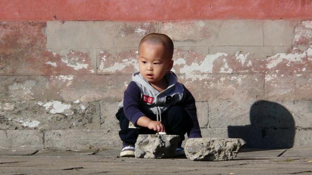 Dítě v Pekingu si hraje na ulici