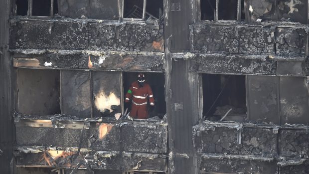 Hasiči prohledávají budovu Grenfell Tower po požáru.
