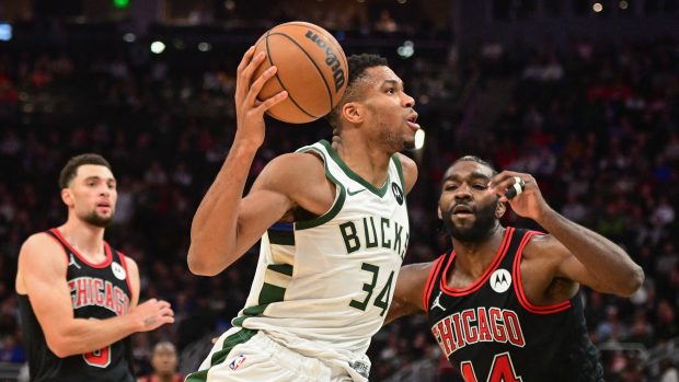 Útočník Milwaukee Bucks Janis Adetokunbo vede přes útočníka Chicaga Bulls Patricka Williamse