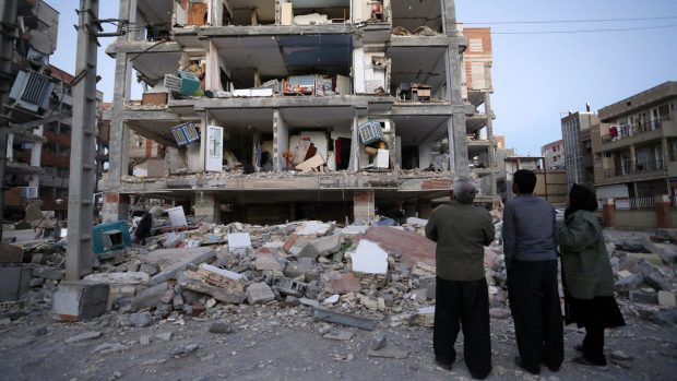 Lidé se ve městě Sarpol-e Zahab na západě Íránu dívají na dům, který poničilo silné zemětřesení