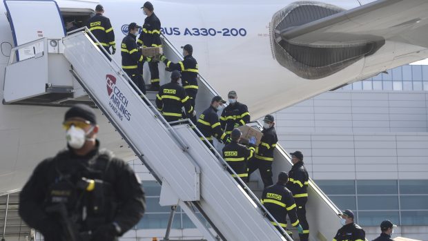 Hasiči vykládají letadlo, které v pátek přivezlo do Čech z Číny přes milion respirátorů FFP2