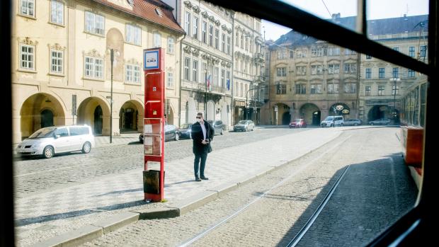 Osamocený muž na tramvajové zastávce