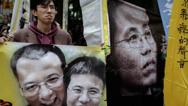 Demonstrant v Hongkongu požaduje propuštění vězněného disidentského páru Liou Siao-po a Liou Sia, archivní snímek z března roku 2014. Liou Siao-po byl čínským režimem vězněn od konce roku 2008 až do své letošní smrti. Liou Sia uvrhli do domácího vězení v roce 2010 - poté co její manžel obdržel Nobelovu cenu míru.