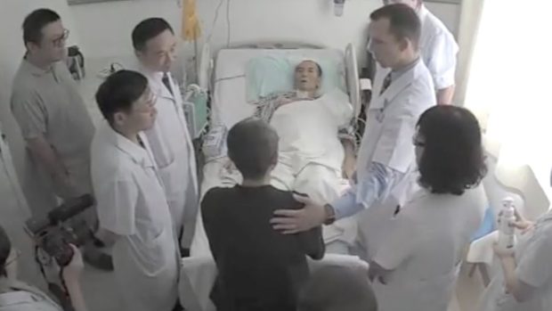 Umírající Liou Siao-po na nemocničním lůžku během vyšetření zahraničních lékařů, které povolil čínský režim.  V černém před postelí Liouova manželka Liou Sia, známá básnířka, kterou vláda roky internovala v domácím vězení. Výsledkem je klinická deprese.