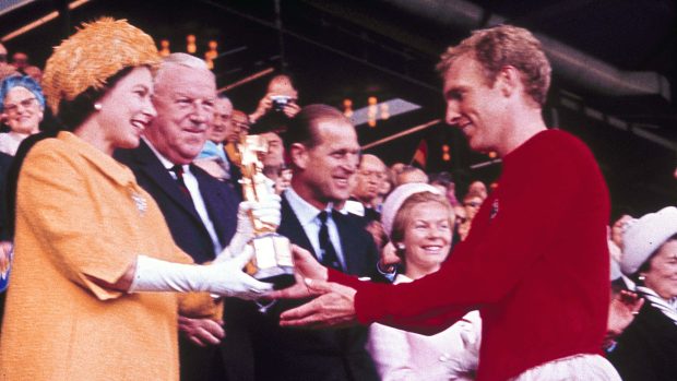 Královna Alžběta II. předává kapitánovi domácích Bobbymu Mooreovi trofej pro mistry světa