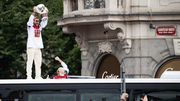 Prvním, kdo fanouškům na Staroměstském náměstí v Praze ukázal vítěznou trofej, byl David Pastrňák. Vylezl na střechu autobusu, kterým hokejisté přijeli.