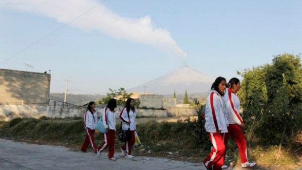 Mexické studentky v San Nicolas de los Ranchos, v pozadí kouřící Popocatépetl