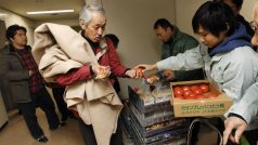 Lidé dostávají potraviny v evakuačním centru ve městě Sendai.