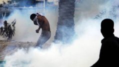 Protestující mladík je přemožen slzným plynem v bahrajnské Manámě