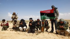 Libyjští povstalci se modlí u hrobu rebelů, kteří byli zabiti při útok na konvoj v okolí přístavu Brega