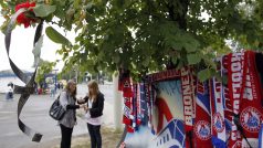 Ženy zapalují svíčky před hokejovým stadionem v Jaroslavli.