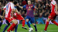 Andrés Iniesta se snaží proniknout mezi hráči Gijónu v Primera División
