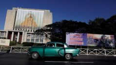 Auto jede v Havaně kolem bilboardu milosrdné panny z Cobre, patronky Kuby