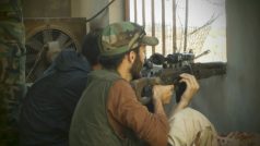 Ozbrojený člen Syrské osvobozenecké armády brání dům v Homsu