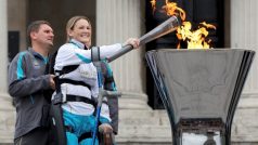 Paralympionička Claire Lomasová, stojíc na robotických nohou, zapaluje paralympijský oheň na Trafalgarském náměstí v Londýně