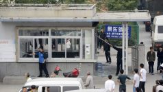 Dělníci čínské továrny Foxconn uklízejí rozbité sklo po noční potyčce