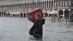 Turistka prochází zaplaveným náměstím Svatého Marka v italských Benátkách