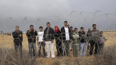 Palestinci stojící  u plotu, který odděluje pásmo Gazy od Izraele