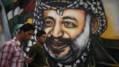 Palestinci v Gaze procházejí kolem portrétu Jásira Arafata