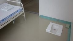 Záchytná místnost včetně tureckého záchodu a postele zapuštěné do betonu