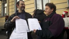 Aktivista Dimitrij Litvinov a  kapitán lodi Greenpeace Peter Willcox  ukazují doklady o  zastavení svého stíhání