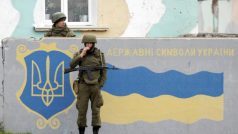 Ruský voják před namalovanou ukrajinskou vlajkou (ilustrační foto)