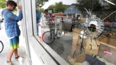 Střelec zabil v Kalifornii šest lidí. Muž se dívá skrze okno, na kterém jsou vidět stopy po kulkách