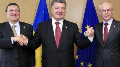 Ukrajinský prezident Petro Porošenko (uprostřed) podepsal v Bruselu asociační dohodu. Blahopřejí mu šéf Evropské komise Jose Manuel Barroso a prezident EU Herman Van Rompuy. 27. 6. 2014