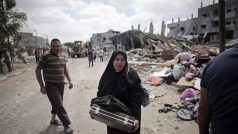Palestinská žena se snaží zachránit, co se dá, z trosek svého zničeného domu