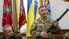 Ukrajinský vojenský velitel ukazuje pušku, kterou zabavili ruským vojákům