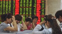 Investoři sledují kurz na trhu s cennými papíry ve městě Fuyang v provincii Anhui