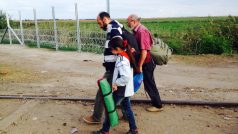 Migranti v Röszke na maďarsko-srbské hranici - cesta skrz plot