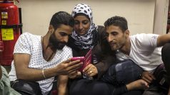 Syrští uprchlíci sledují video na mobilním telefonu