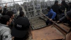 Migranti se snaží proniknout přes bariéru na řecko-makedonské hranici