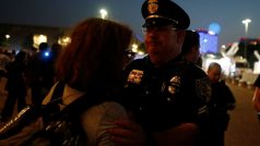 Policista utěšuje plačící ženu u radnice v Dallasu