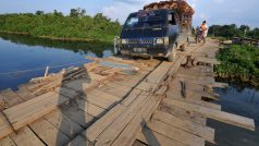 Kamion převážející palmy olejné přes most v Indonésii