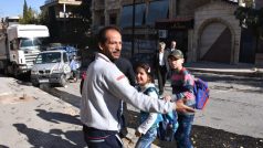 Muž evakuuje děti ze školy v západním Aleppu, kterou podle syrské televite zasáhly rakety opozice.