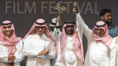 Cenou Saúdského filmového festivalu je Zlatá palma. Z čestného ocenění se na snímku z letošního zahajovacího ceremoniálu raduje režisér a herec Saed Chádir (uprostřed).