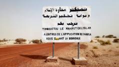Cedule na cestě do Timbuktu napsaná islamistickými povstalci z roku 2013. Stojí na ní: Timbuktu, minaret islámu a brána k uplatňování zákona šaría vás vítá.