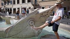 Muž se v létě ochlazuje u římské fontány Barcaccia.