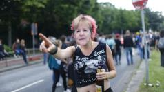 Žena s maskou německé kancléřky Angely Merkelové během protestu před summitem G20 v Hamburku