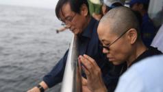 Liou Sia (vpravo) sleduje vlny moře, kam ji úřady navzdory čínské pohřební tradici donutily rozprášit popel jejího manžela Liou Siao-poa. Po zesnulém disidentovi neměla zbýt památka.