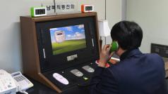 Jihokorejský vládní úředník prověřuje spojení se Severní Koreou přes znovu otevřenou komunikační horkou linku v pohraniční vesnici Pchanmundžom (3. ledna 2018).