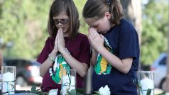 Děti se modlí při tryzně za deset obětí střelby na škole v americkém Santa Fe
