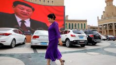 Ujgurka prochází kolem obří plochy s podobiznou čínského prezidenta Si Ťin-pchinga na hlavním náměstí ve městě Kašgar voblasti Sin-ťiang.
